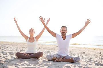 Image showing smiling couple making yoga exercises outdoors