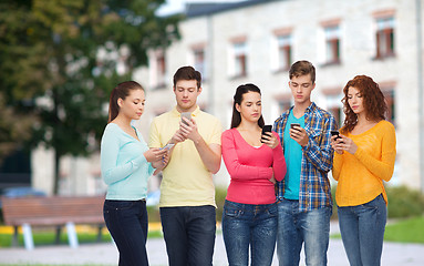 Image showing group of serious teenagers with smartphones