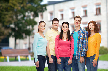 Image showing group of smiling teenagers over campus background