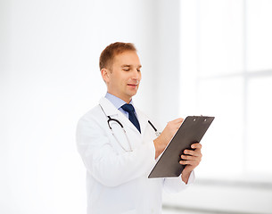 Image showing smiling male doctor with clipboard and stethoscope