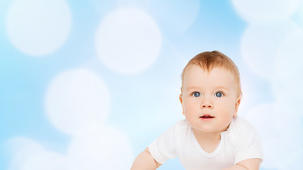 Image showing smiling baby lying on floor and looking up