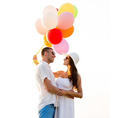 Image showing smiling couple with air balloons outdoors