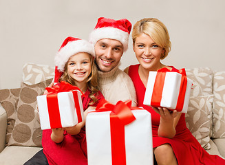 Image showing smiling family giving many gift boxes