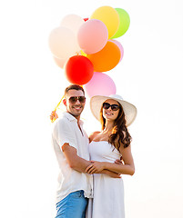 Image showing smiling couple with air balloons outdoors