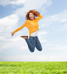 Image showing smiling young woman jumping in air