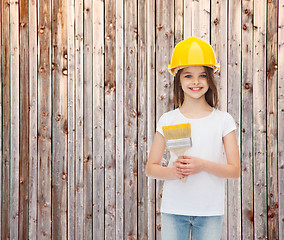 Image showing smiling little girl in helmet with paint brush