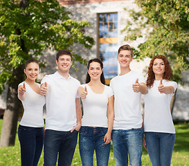 Image showing smiling teenagers in t-shirts showing thumbs up