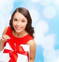 Image showing smiling woman in red dress with gift box