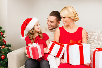 Image showing smiling family holding many gift boxes