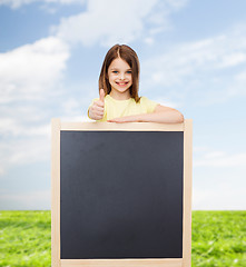 Image showing happy little girl with blank blackboard