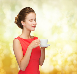 Image showing smiling woman in red dress with cup of coffee