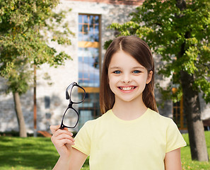 Image showing smiling cute little girl holding black eyeglasses