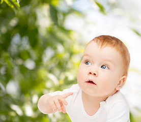 Image showing curious baby lying on floor and looking side