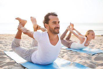 Image showing couple making yoga exercises outdoors