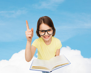 Image showing smiling little girl in eyeglasses with book