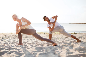 Image showing couple making yoga exercises outdoors