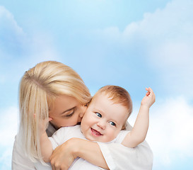 Image showing happy mother kissing smiling baby