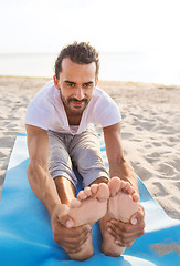 Image showing man doing yoga exercises outdoors