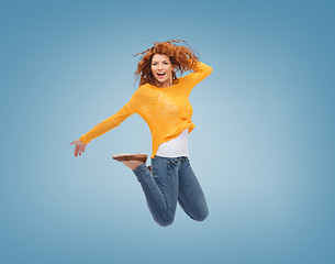 Image showing smiling young woman jumping in air