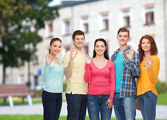 Image showing group of smiling teenagers over campus background