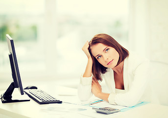 Image showing woman with computer, papers and calculator