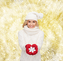 Image showing smiling woman in winter clothes with snowflake