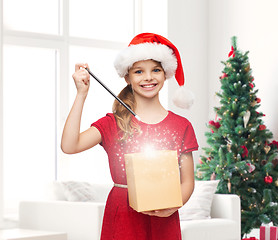 Image showing smiling girl in santa helper hat with gift box