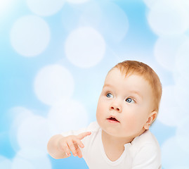 Image showing curious baby lying on floor and looking side