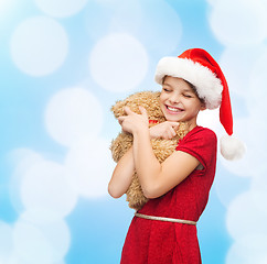 Image showing smiling girl in santa helper hat with teddy bear