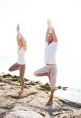 Image showing couple making yoga exercises outdoors