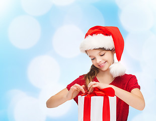 Image showing smiling girl in santa helper hat with gift box