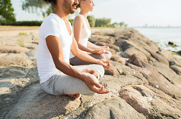 Image showing close up of couple making yoga exercises outdoors