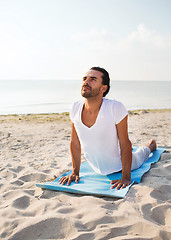 Image showing man doing yoga exercises outdoors