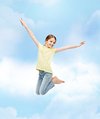 Image showing smiling little girl jumping