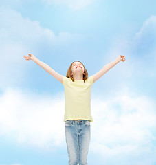 Image showing smiling teenage girl with raised hands