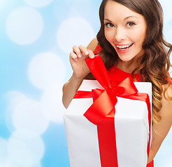 Image showing smiling woman in red dress with gift box