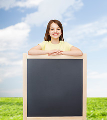 Image showing happy little girl with blank blackboard