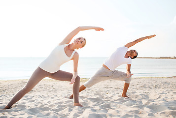 Image showing couple making yoga exercises outdoors