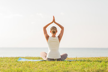 Image showing woman making yoga exercises outdoors