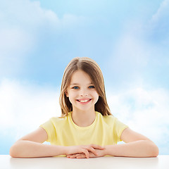 Image showing beautiful little girl sitting at table