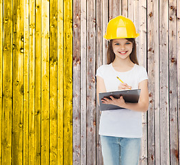 Image showing smiling little girl in hardhat with clipboard