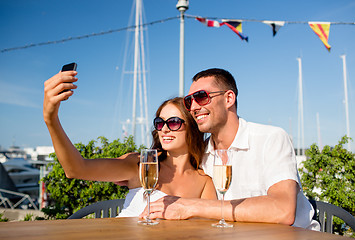 Image showing smiling couple drinking champagne at cafe