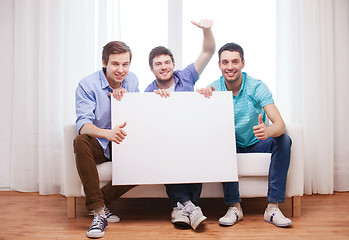 Image showing happy male friends with blank white board at home