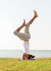 Image showing man making yoga exercises outdoors