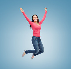 Image showing smiling young woman jumping in air