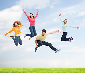 Image showing group of smiling teenagers jumping in air