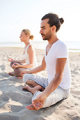 Image showing smiling couple making yoga exercises outdoors