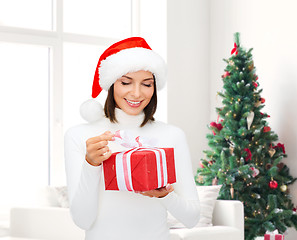 Image showing smiling woman in santa helper hat with gift box