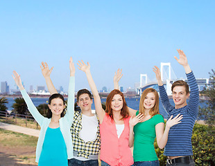 Image showing group of smiling students waving hands