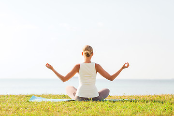 Image showing woman making yoga exercises outdoors